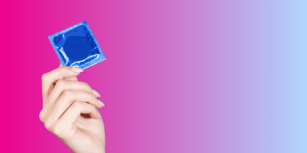 woman's hand holds condom in blue wrapper