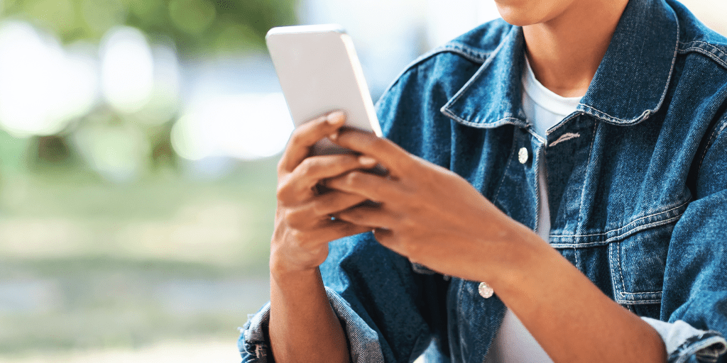 image of a women in a denim jacket searching her smart phone