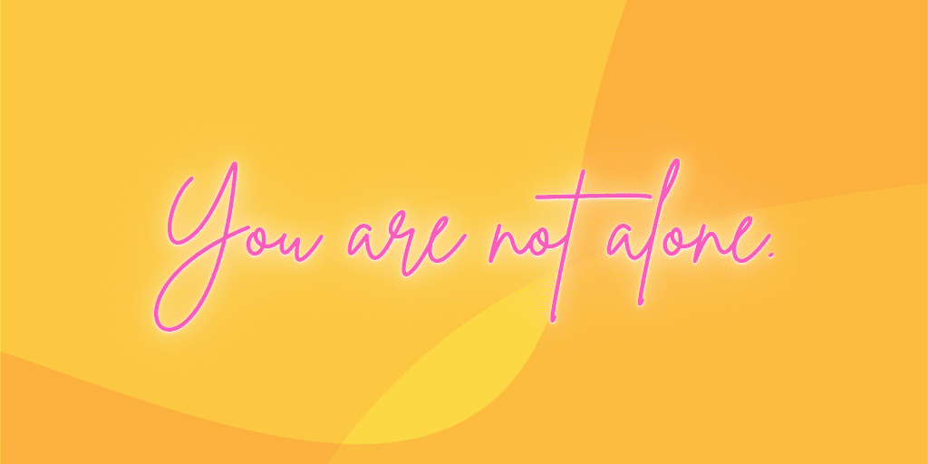 Graphic with a yellow and orange background features pink words which read, "You are not alone."