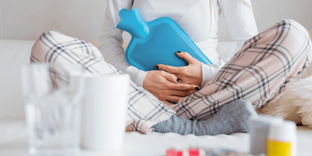 Woman holds a hot water bottle to relieve period cramps